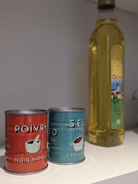 Basic cooking essentials provided Two spice tins labelled "Poivre" and "Sel" beside a bottle of olive oil.