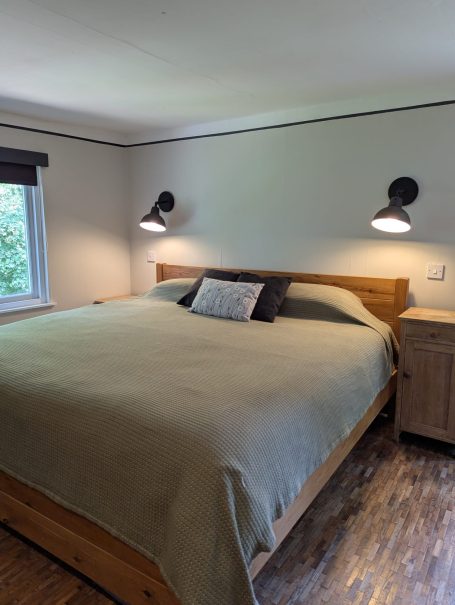 Cosy bedroom with huge bed Cozy bedroom featuring a large bed, wooden nightstands, and natural light.
